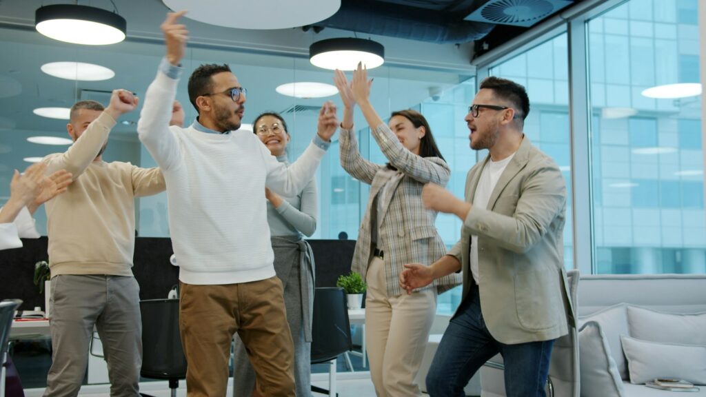 Equipo de colegas celebrando un logro en la oficina